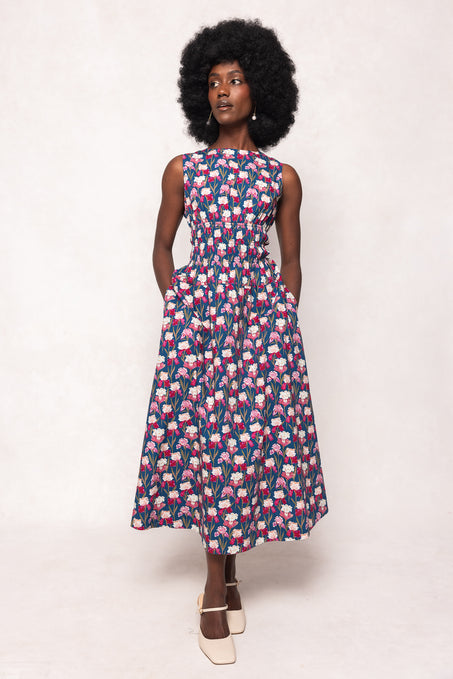 Woman wearing a sleeveless dress with a floral pattern on a white background