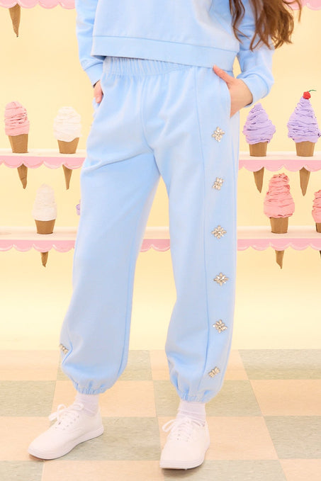 Woman wearing a light blue outfit with a patterned ice cream background