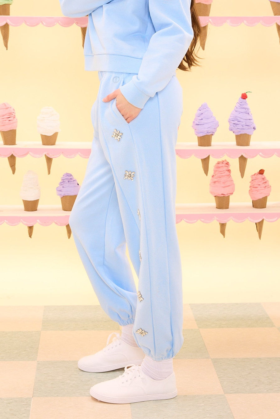 Person wearing a light blue tracksuit with ice cream cone background