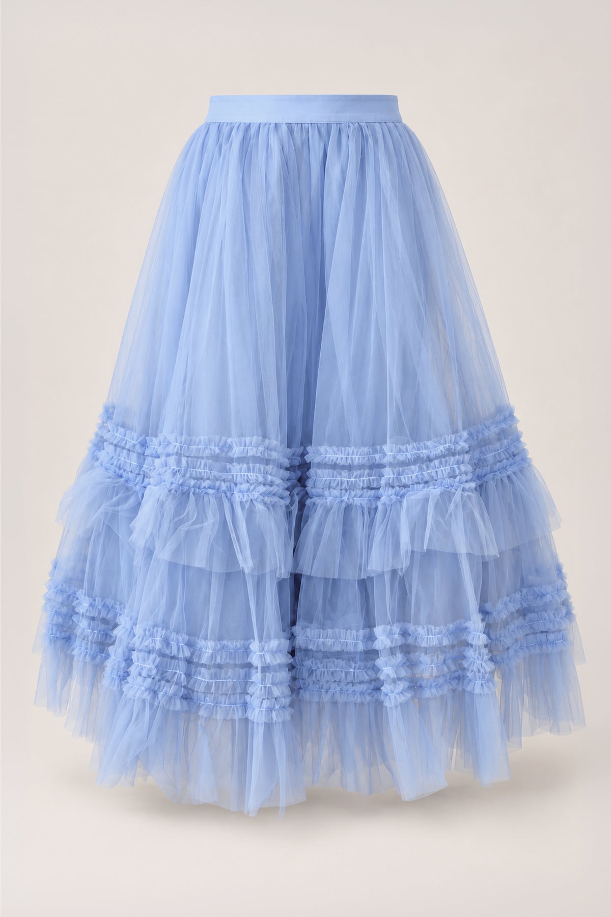 The Celestine Skirt in Misty Blue by Ivy City Co features voluminous layers of misty blue tulle with cascading ruffled tiers and a fitted waistband, displayed on a simple light background—an enchanting girls’ skirt that’s perfect for a holiday recital outfit.