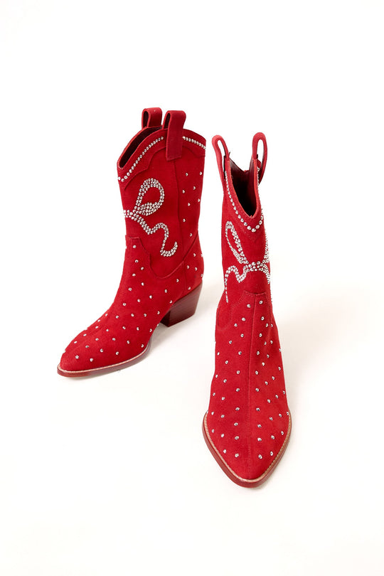 The Channing Bootie in Red by Ivy City Co is displayed on a white background, with one boot upright and the other angled forward to highlight its unique features. These red suede cowboy booties feature silver studs, decorative stitching, and a standout heel—an eye-catching choice for anyone seeking western sparkly booties with bold style.