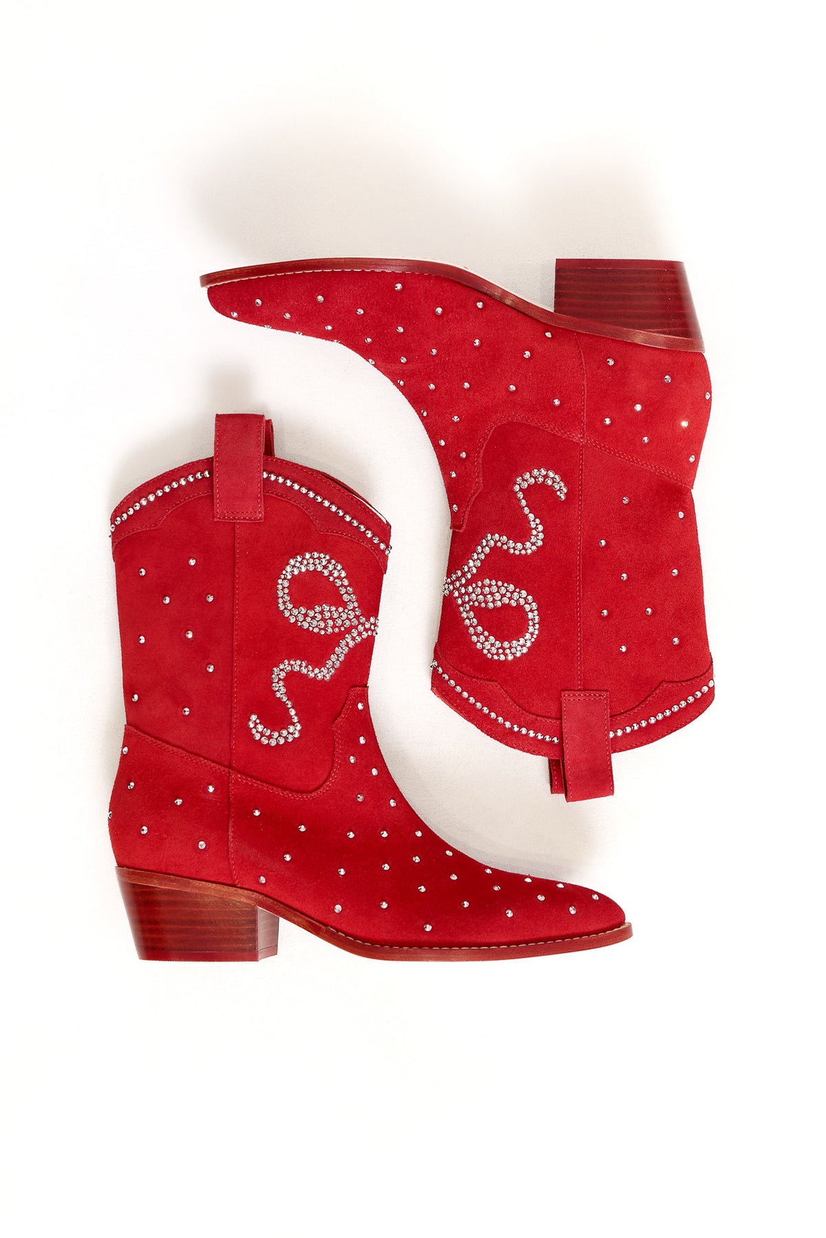 The Channing Bootie in Red by Ivy City Co features red suede, low wooden heels, and sparkling white rhinestones with a swirling side design—ideal for elevating your western booties collection.