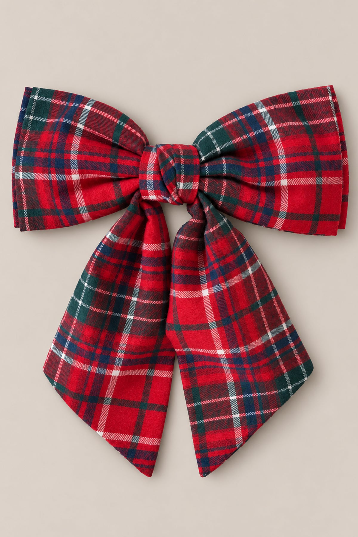 Add a burst of holiday spirit to your look with the Ivy City Co Hair Bows in Christmas Cheer Plaid—featuring wide loops, long ribbon tails, and a classic red-and-green plaid pattern tied at the center—all set against a neutral beige backdrop. This charming accessory is perfect for festive photos or any Christmas occasion.