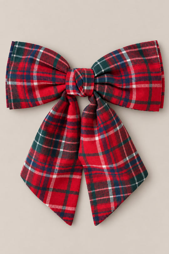 Add a burst of holiday spirit to your look with the Ivy City Co Hair Bows in Christmas Cheer Plaid—featuring wide loops, long ribbon tails, and a classic red-and-green plaid pattern tied at the center—all set against a neutral beige backdrop. This charming accessory is perfect for festive photos or any Christmas occasion.