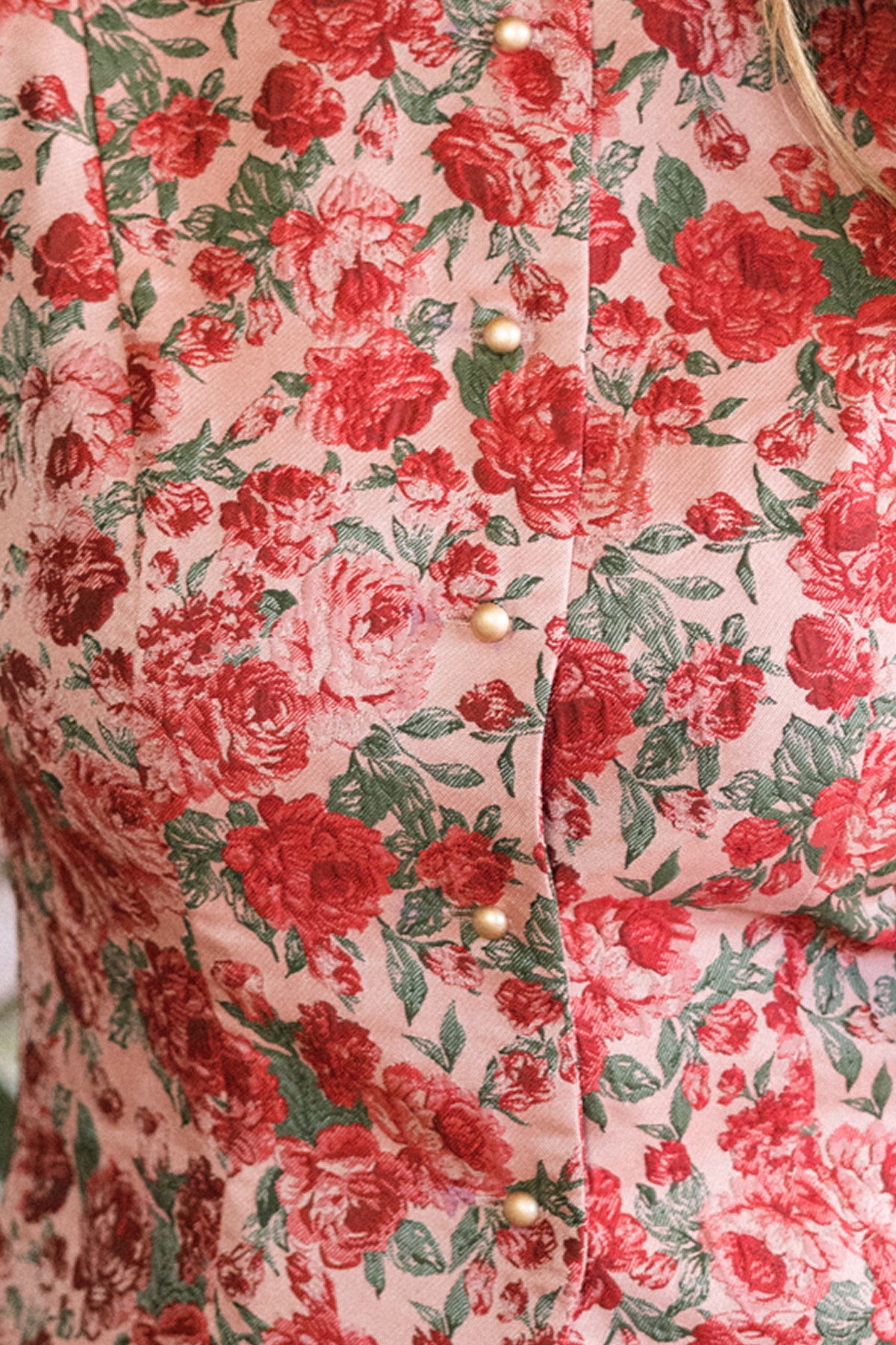 Close-up of the Ciara Vest in Antiquity Rose by Ivy City Co, featuring a pink and red floral pattern with gold buttons—an elegant, nursing-friendly piece perfect for holiday parties.