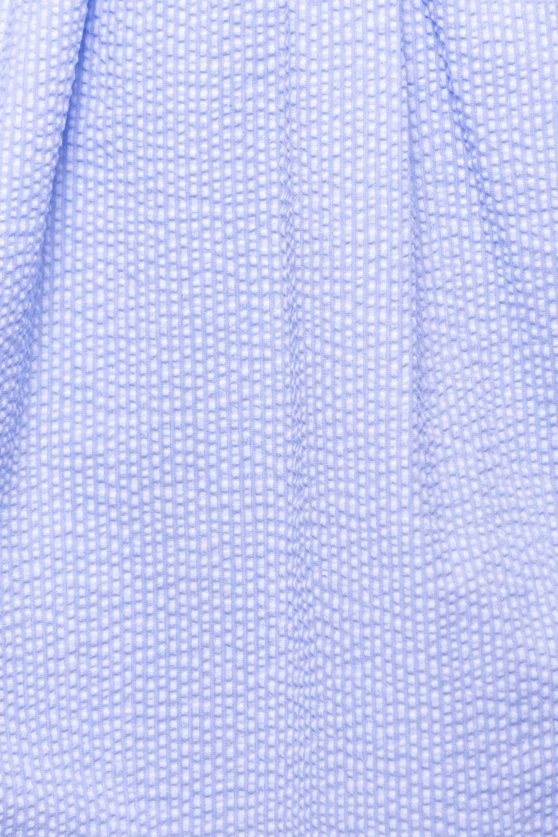 Close-up of Ivy City Cos Countryside Dress in Blue Seersucker, featuring light blue puckered fabric with a subtle checkered texture—ideal for nursing and maternity-friendly wear.