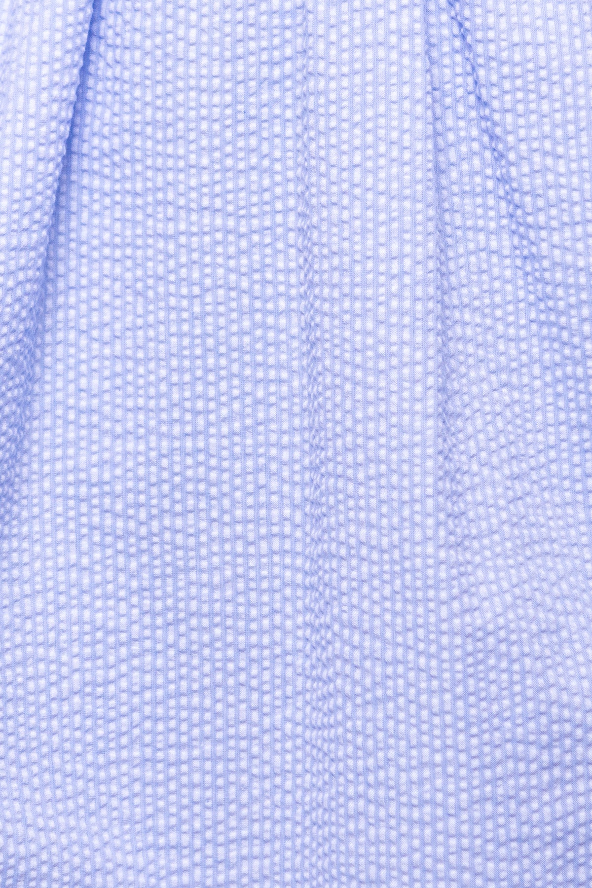 Close-up of Ivy City Cos Countryside Dress in Blue Seersucker, featuring light blue puckered fabric with a subtle checkered texture—ideal for nursing and maternity-friendly wear.