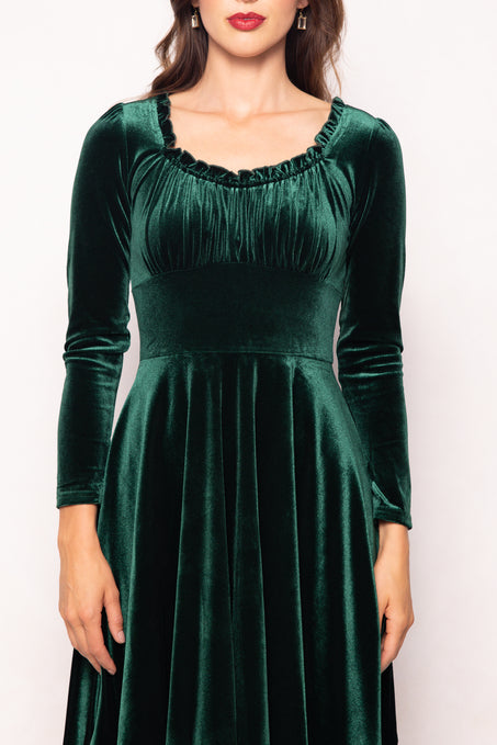 Green velvet dress worn by a model on a white background