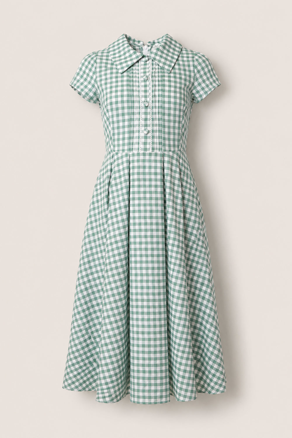 The Amber Dress in Sage Gingham by Ivy City Co features green and white checks on a cotton midi silhouette, complete with short sleeves, a fitted bodice, button-down front, and flared pleated skirt. Designed with a pointed collar and pleated detailing below the waist, this dress offers timeless charm.