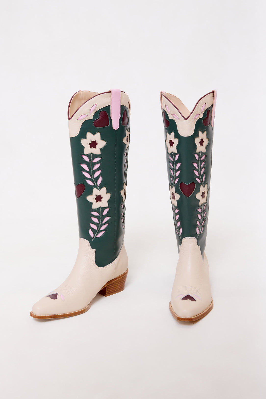 Green and beige cowboy boots with floral embroidery on a white background