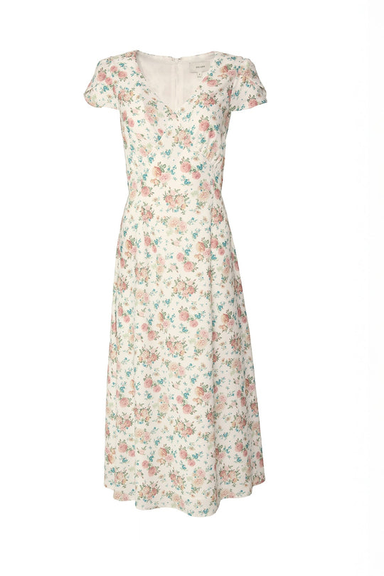 The Fiona Dress in Countryside Peony Blossom by Ivy City Co is a white, short-sleeved midi dress with a V-neckline, adorned with an elegant pink and blue peony blossom pattern. Designed with a fitted waist and flared skirt for a flattering silhouette, this floral summer dress is showcased against a plain white background.