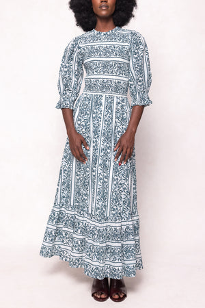 Woman wearing a blue and white patterned dress on a white background