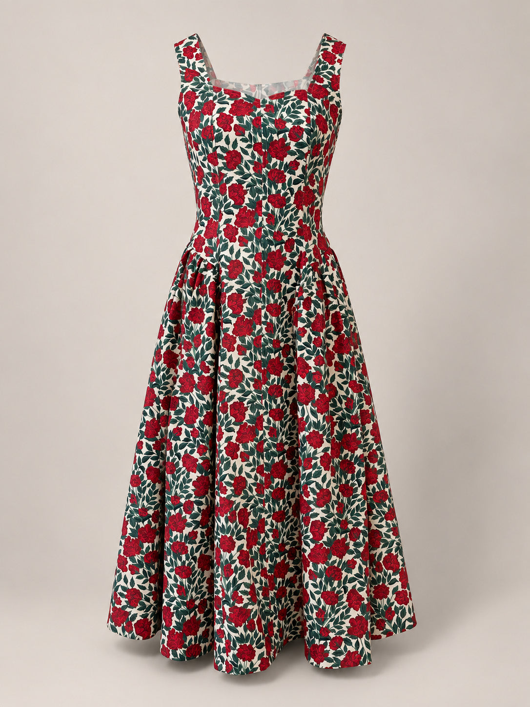 The Edith Dress in Red Roses by Ivy City Co is a sleeveless, vintage-inspired floral dress with a fitted bodice and flared skirt, showcasing a striking red and green rose pattern on a white background. The dress is presented against a neutral backdrop.
