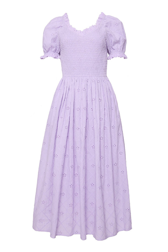 Introducing the Emmi Dress in Lilac by Ivy City Co: this ankle-length dress showcases puffed short sleeves, a smocked bodice, and a ruffled neckline. Subtle floral eyelet cotton patterns embellish the skirt and sleeves, adding delicate charm to its maternity-friendly silhouette.