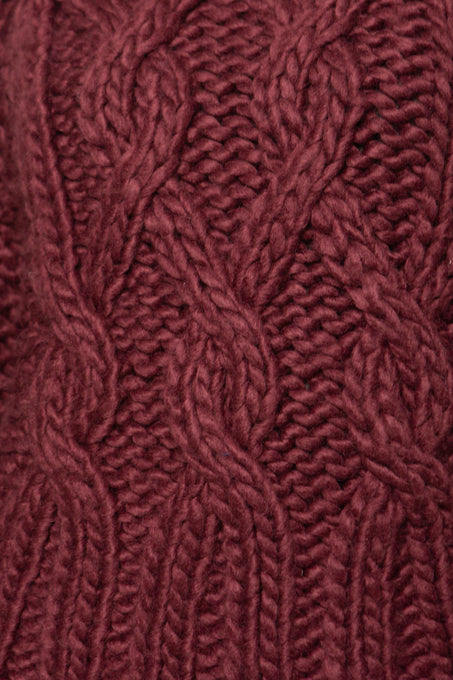 Close-up of a textured burgundy fabric with a cable knit pattern