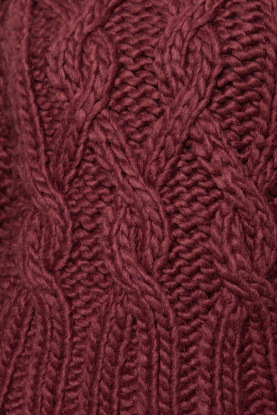 Close-up of a textured burgundy fabric with a cable knit pattern