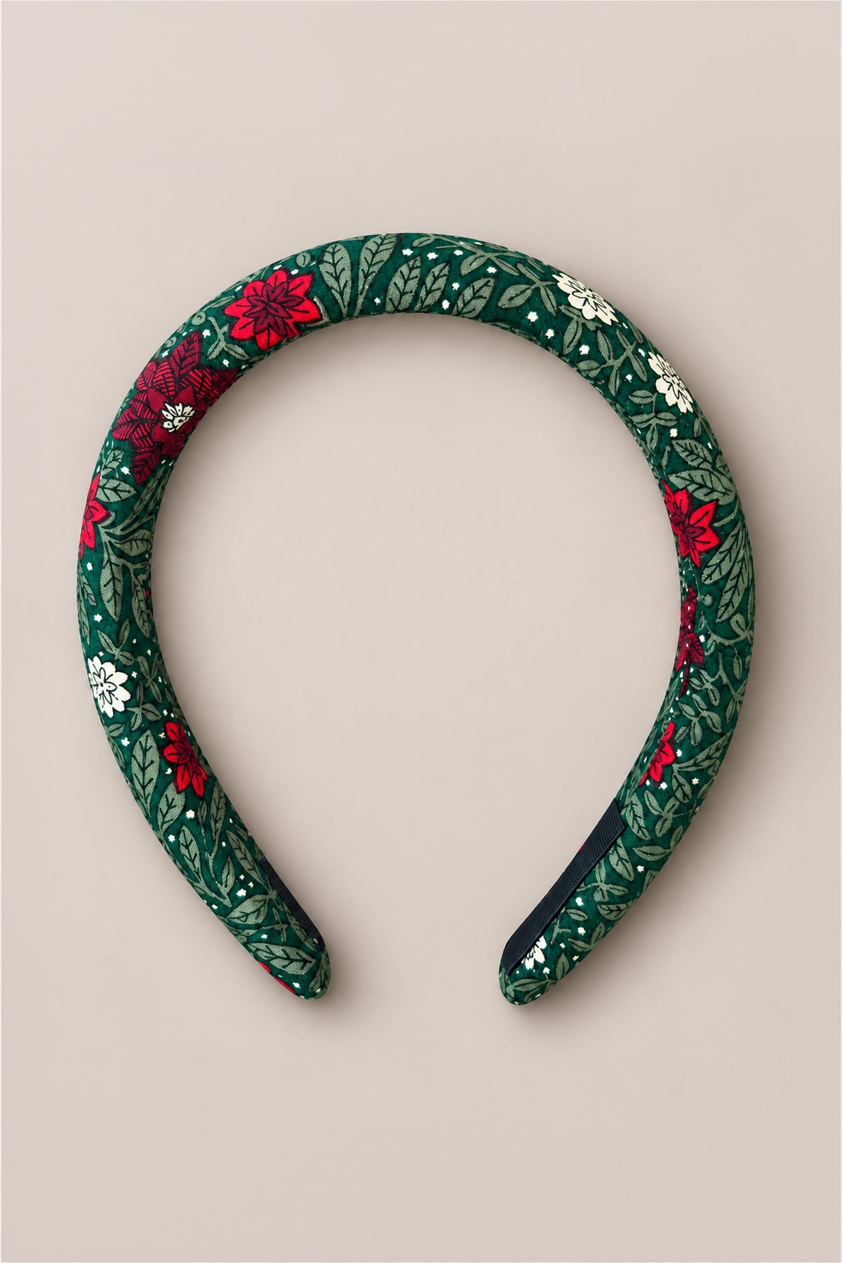The Ivy City Co Hair Bows in Evergreen Merry Ditsy showcase a padded cotton design with a green leafy and ditsy floral pattern featuring red and white flowers, presented on a plain beige background.