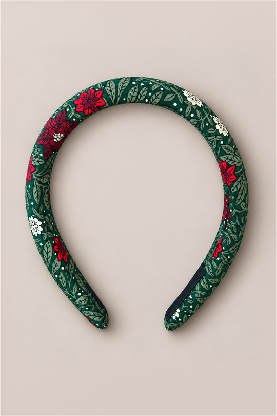 The Ivy City Co Hair Bows in Evergreen Merry Ditsy showcase a padded cotton design with a green leafy and ditsy floral pattern featuring red and white flowers, presented on a plain beige background.