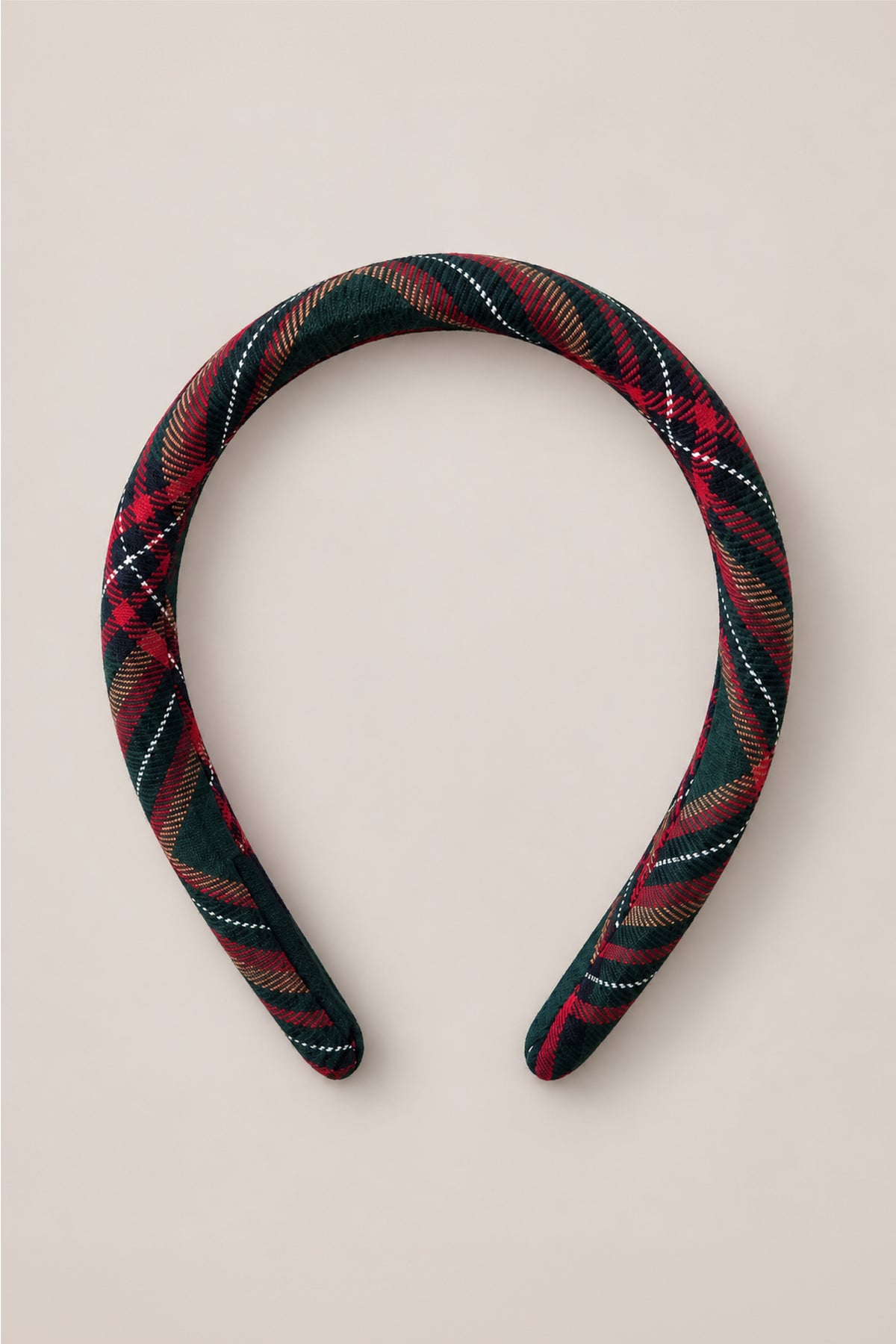 The Ivy City Co Hair Bows in Evergreen Plaid feature a padded headband covered in dark green, red, and white flannel fabric, beautifully showcased against a light beige background.