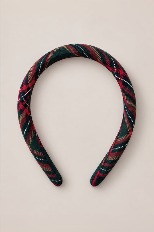The Ivy City Co Hair Bows in Evergreen Plaid feature a padded headband covered in dark green, red, and white flannel fabric, beautifully showcased against a light beige background.