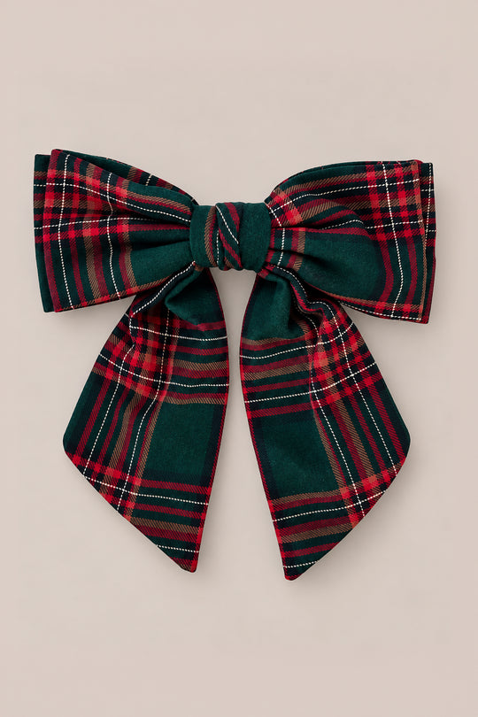 The Ivy City Co Hair Bows in Evergreen Plaid feature a large, neatly tied bow made from soft cotton flannel in a classic red, green, and white evergreen plaid pattern, displayed against a plain beige background.