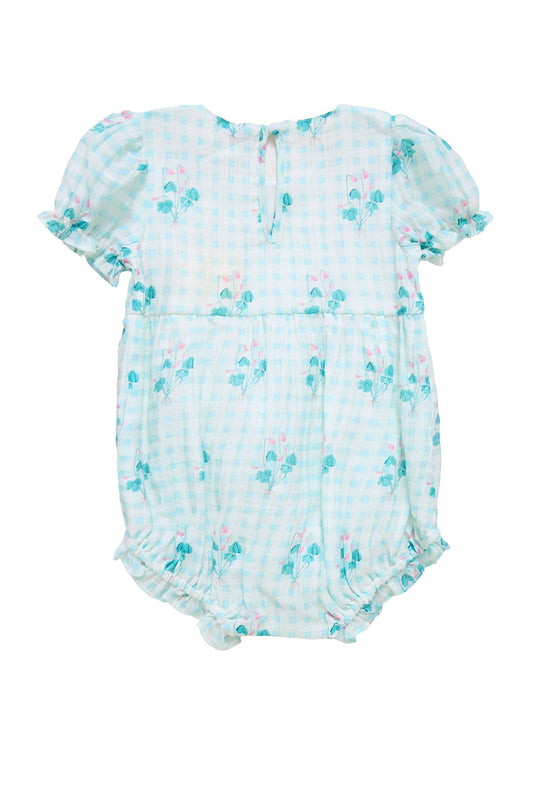 The Baby Jessie Romper in Bloom Gingham by Ivy City Co features a charming light blue and white gingham pattern with short puff sleeves, delicate floral details, ruffled leg openings, and a small button closure at the back—making it a perfect Easter outfit for your little one.