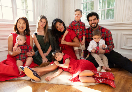 a family sits on the floor in front of windows
