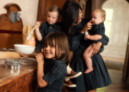 A mom baking with her children in the kitchen