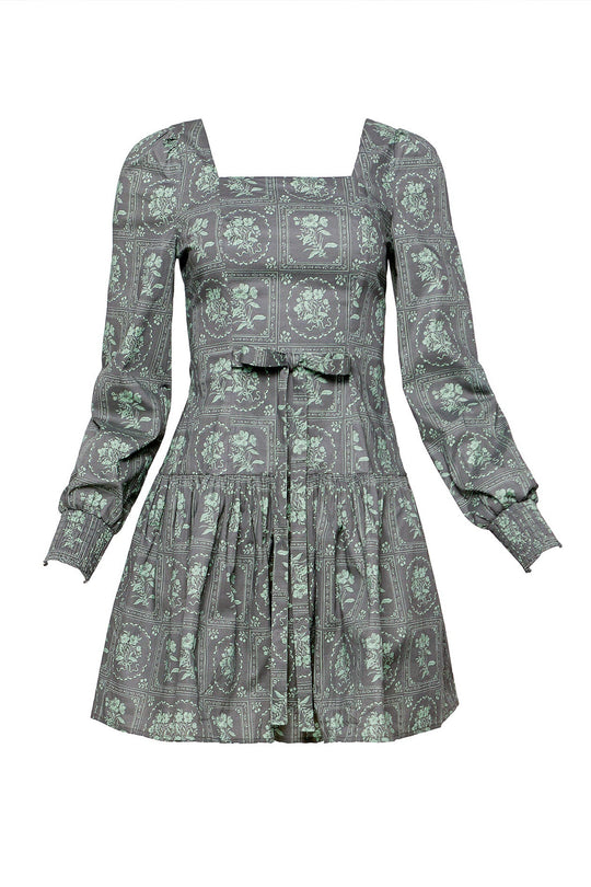 The Finn Dress in Garden Tile by Ivy City Co is a gray long-sleeve mini dress featuring a vintage-inspired green floral print, square neckline, gathered skirt, smocked cuffs, fitted waist, and a subtle front bow detail.