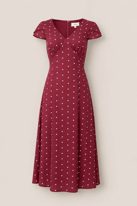 Step into timeless elegance with the Fiona Dress in Cranberry Dainty Dot by Ivy City Co—a charming maroon midi dress sprinkled with a classic white polka dot pattern. Designed with petal sleeves, a flattering V-neckline, and a fitted waist, this versatile piece is perfect for refreshing your fall wardrobe. Shown beautifully against a neutral background.