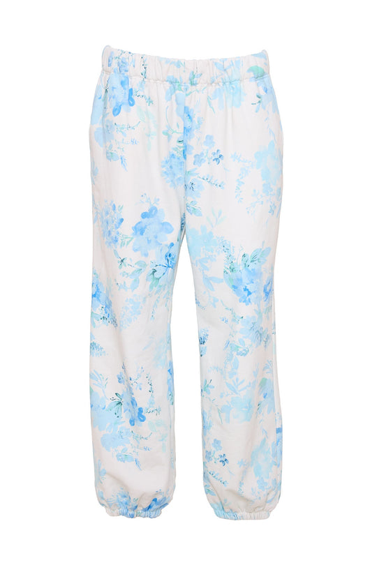 The Kian Jogger Sweatpants in Blue Aquarelle Fleur by Ivy City Co feature a white base with a light blue floral pattern, an elastic waistband and ankle cuffs, side pockets, and a loose, comfortable fit.