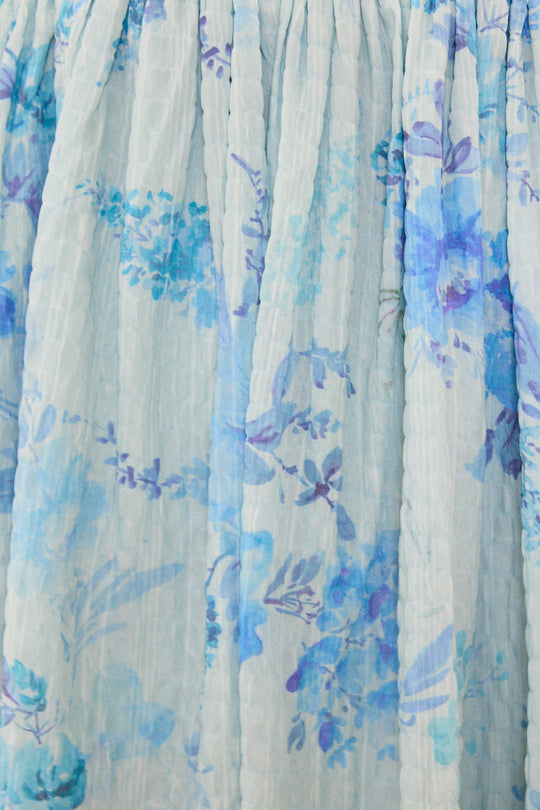 Close-up of a fabric with blue floral pattern on a light background