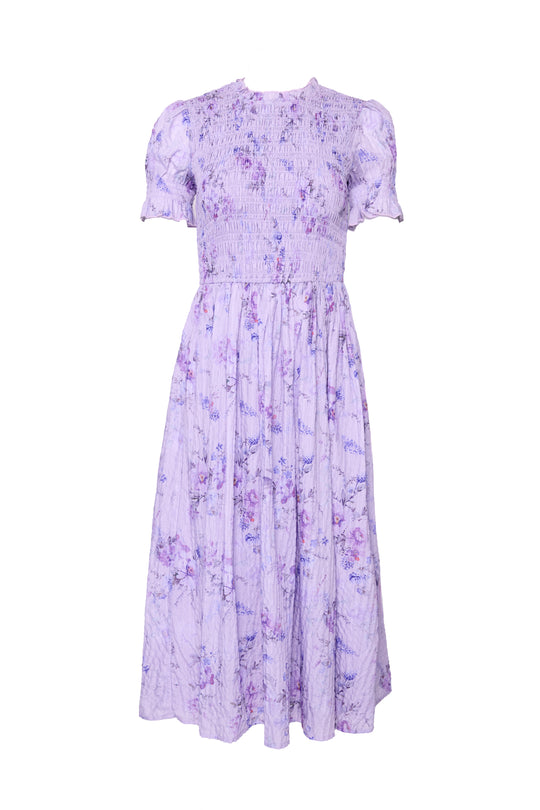 The Ivy City Co Flynn Midi Dress in Lavender Aquarelle Fleur features a floral pattern, smocked bodice, puffed short sleeves, high neckline, gathered skirt, and a maternity-friendly fit for an elegant, feminine look.