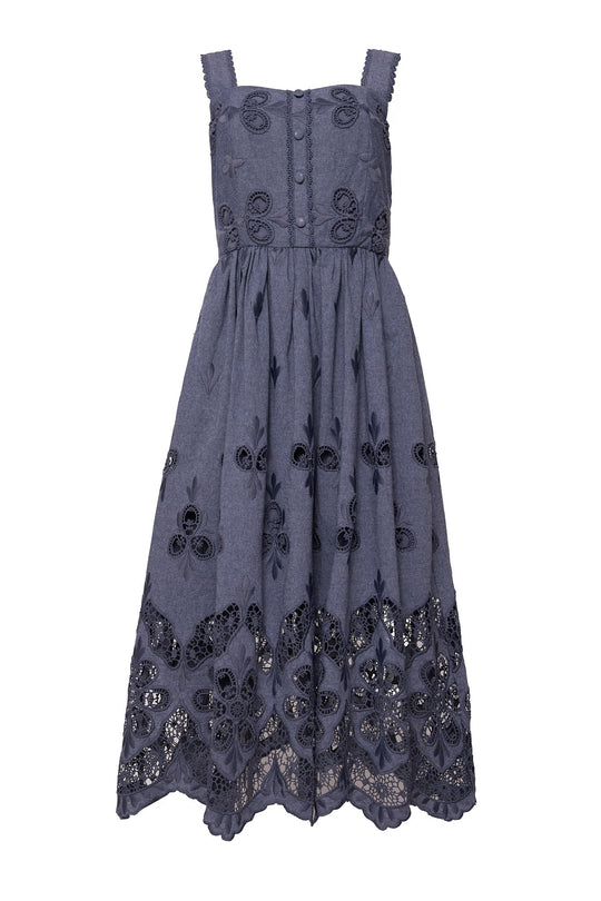 The Penny Tank Midi Dress in Embroidered Chambray by Ivy City Co features a sleeveless navy blue cotton chambray design with a square neckline, button details on the bodice, and a scalloped hem. Delicate eyelet lace and floral embroidery add timeless elegance, while adjustable straps ensure extra comfort in this charming piece.