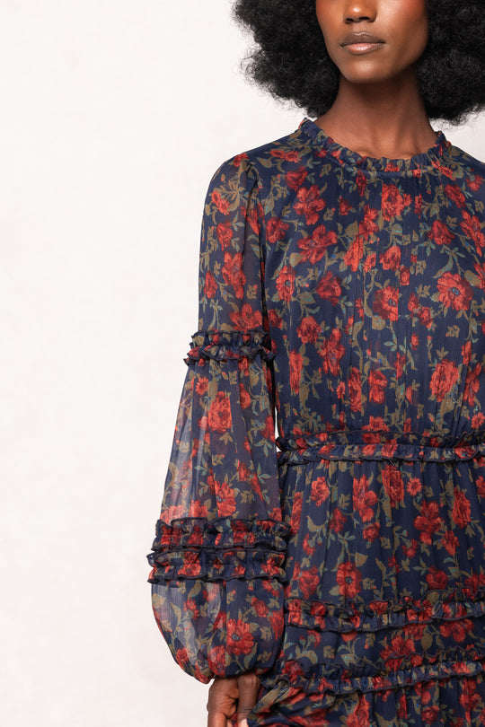 Woman wearing a floral dress with red and blue flowers on a white background