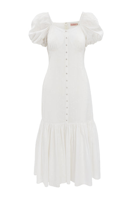 The Liberty Dress in White Eyelet by Ivy City Co features a fit-and-flare silhouette, short puff sleeves, a button-down front, fitted bodice, flared ruffled hem, and an elegant textured eyelet pattern for subtle detail.