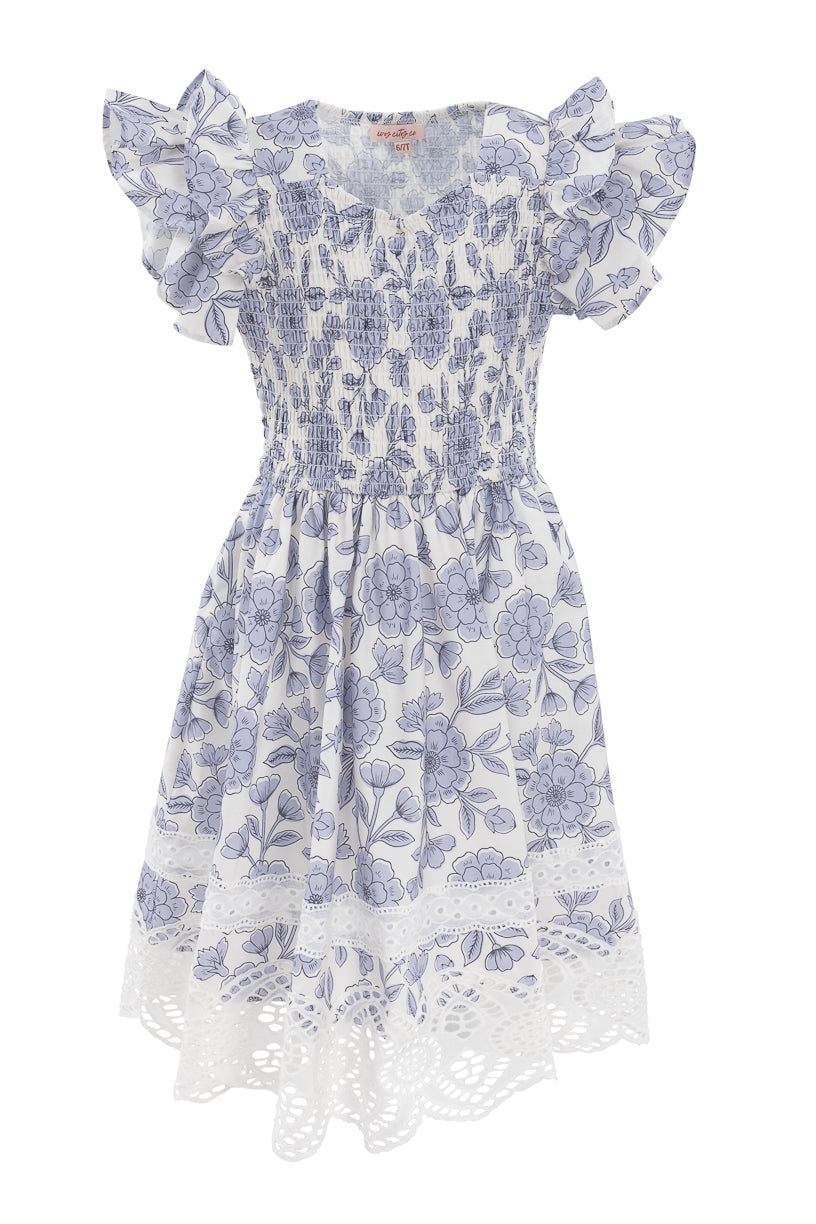 The Mini Hattie Dress in Blue Floral by Ivy City Co features short ruffled sleeves, a shirred bodice, flared skirt, and lace cut-out hem—perfect for sunny days with its playful pattern and charming cotton style.