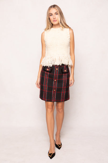 Woman wearing a white sleeveless top and plaid skirt on a white background