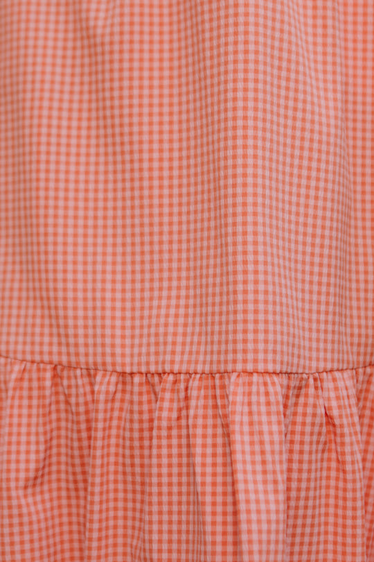 Close-up of the Gidget Dress in Orange Gingham by Ivy City Co, featuring small checks and gathered ruffles—ideal for nursing-friendly or maternity wear.