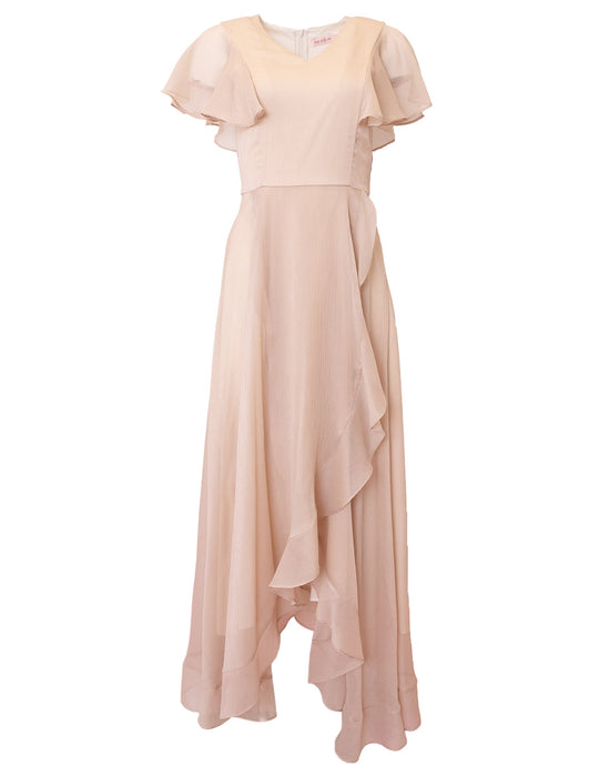 The Callie Dress in Champagne Chiffon by Ivy City Co features a long, light pink design with short flutter sleeves and a flowing, asymmetrical ruffled skirt. Crafted from airy chiffon, this bridesmaid dress offers an effortlessly elegant look.