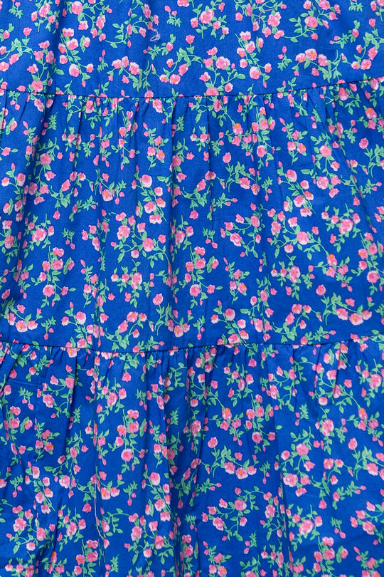 The Hailey Dress in Allie Blue Floral by Ivy City Co features a soft blue floral print with pink flowers and green leaves, tiered ruffled seams, and a stylish, maternity-friendly fit.