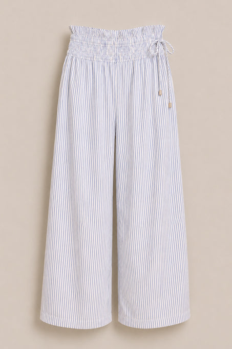 The Harley Pants in Blue & White Pinstripe by Ivy City Co are wide-leg, high-waisted pants with a maternity-friendly elasticated paperbag waistband and drawstring tie, shown against a beige background.