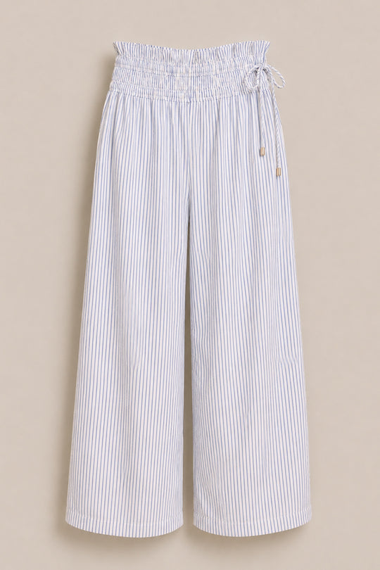 The Harley Pants in Blue & White Pinstripe by Ivy City Co are wide-leg, high-waisted pants with a maternity-friendly elasticated paperbag waistband and drawstring tie, shown against a beige background.