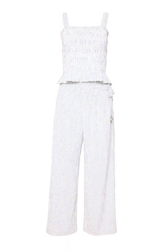 The Harley Pants in Blue & White Pinstripe by Ivy City Co feature a sleeveless, smocked ruffle top, shoulder straps, relaxed fit, wide legs, and subtle waist ruffles. Maternity friendly for added comfort and style.