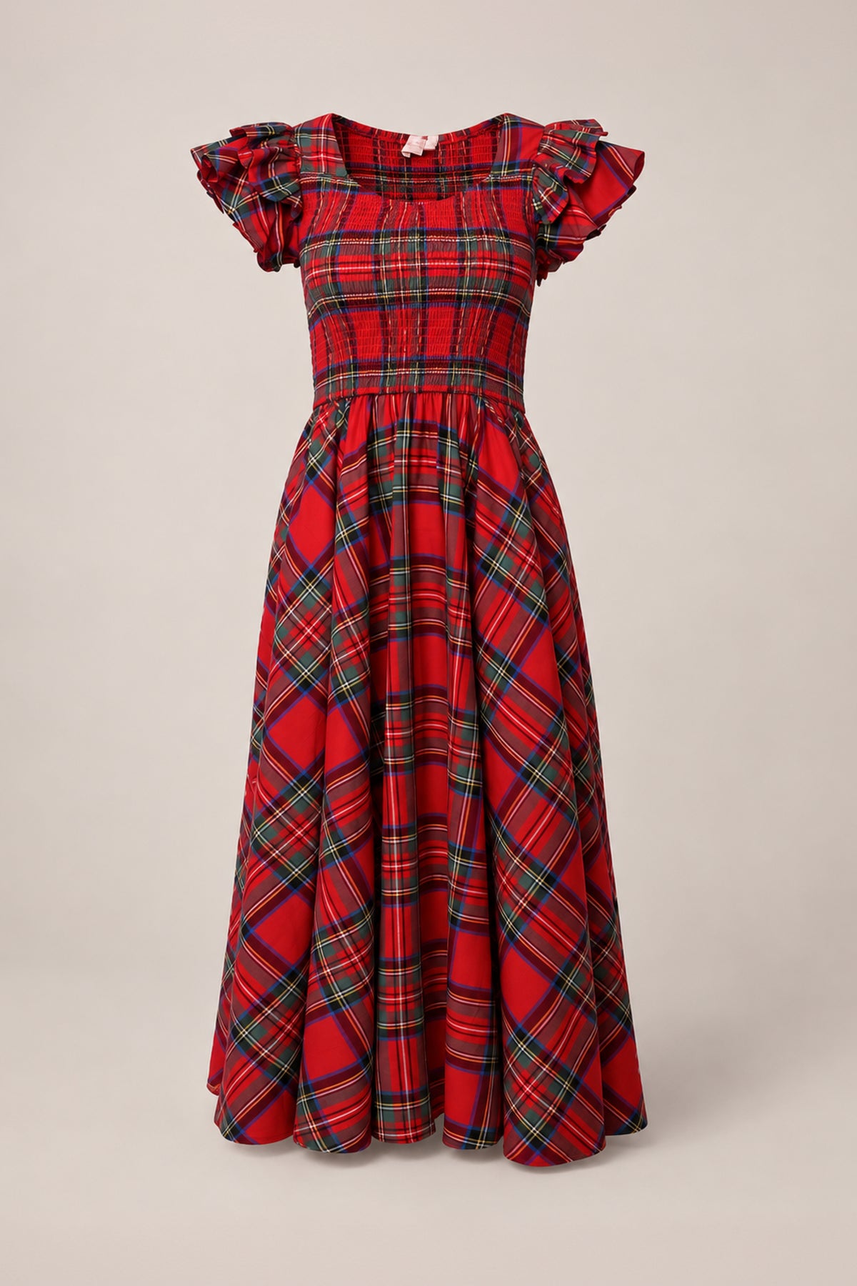 The Hattie Dress in Holiday Plaid by Ivy City Co features a classic red plaid tartan pattern with green, blue, and yellow accents. Designed with ruffled short sleeves, a fitted smocked bodice, and a long, flowing midi-length skirt, this charming maternity-friendly dress combines comfort and style—making it perfect for festive gatherings.
