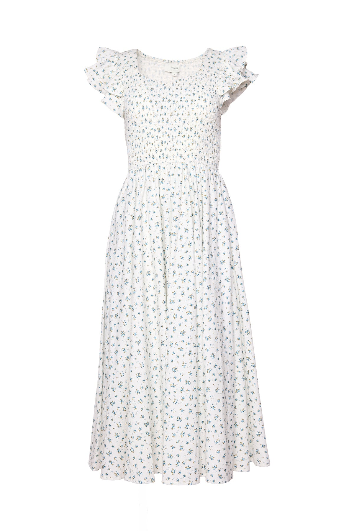 The Hattie Dress in Madeline Blue by Ivy City Co is a white, ankle-length cotton midi dress with a smocked bodice, short ruffled sleeves, and a delicate blue and green floral print. Its flowy skirt highlights the feminine, summery style.