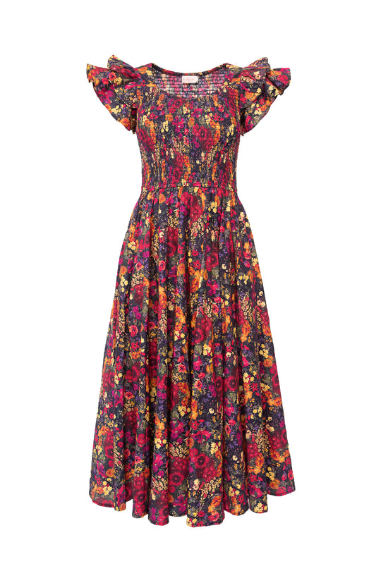 The Hattie Dress in Night Garden by Ivy City Co is a maternity-friendly midi featuring short ruffled sleeves, a smocked bodice, and full skirt in a dark floral print with red, yellow, and purple blooms.