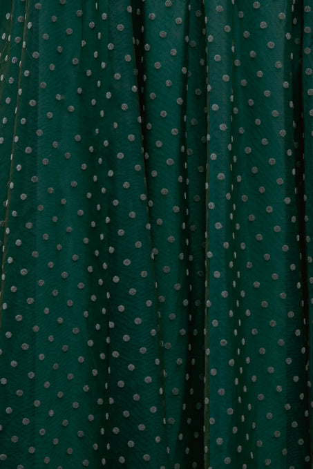 Dark green fabric with small white polka dots