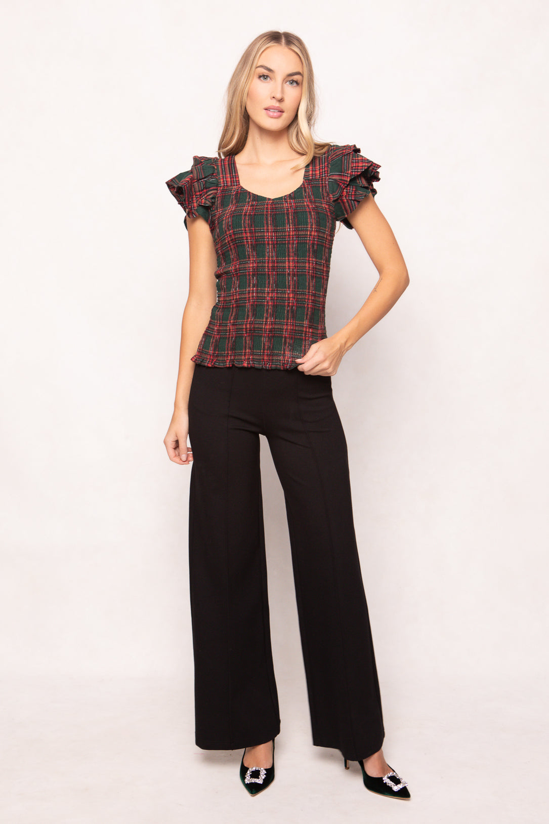 woman is wearing a evergreen plaid top on a white background