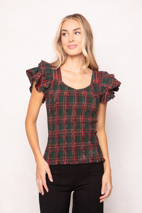 woman is wearing a evergreen plaid top on a white background